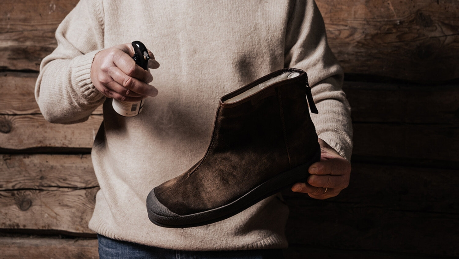 Man applying waterproofing to a pair of suede shoes