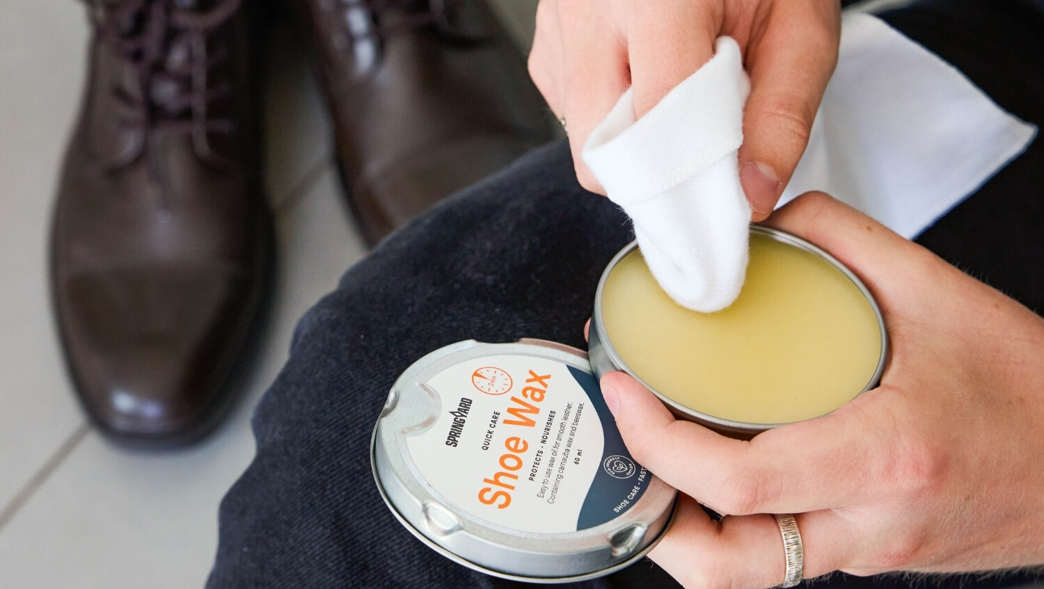 Close-up of shoe wax being applied to leather shoes.