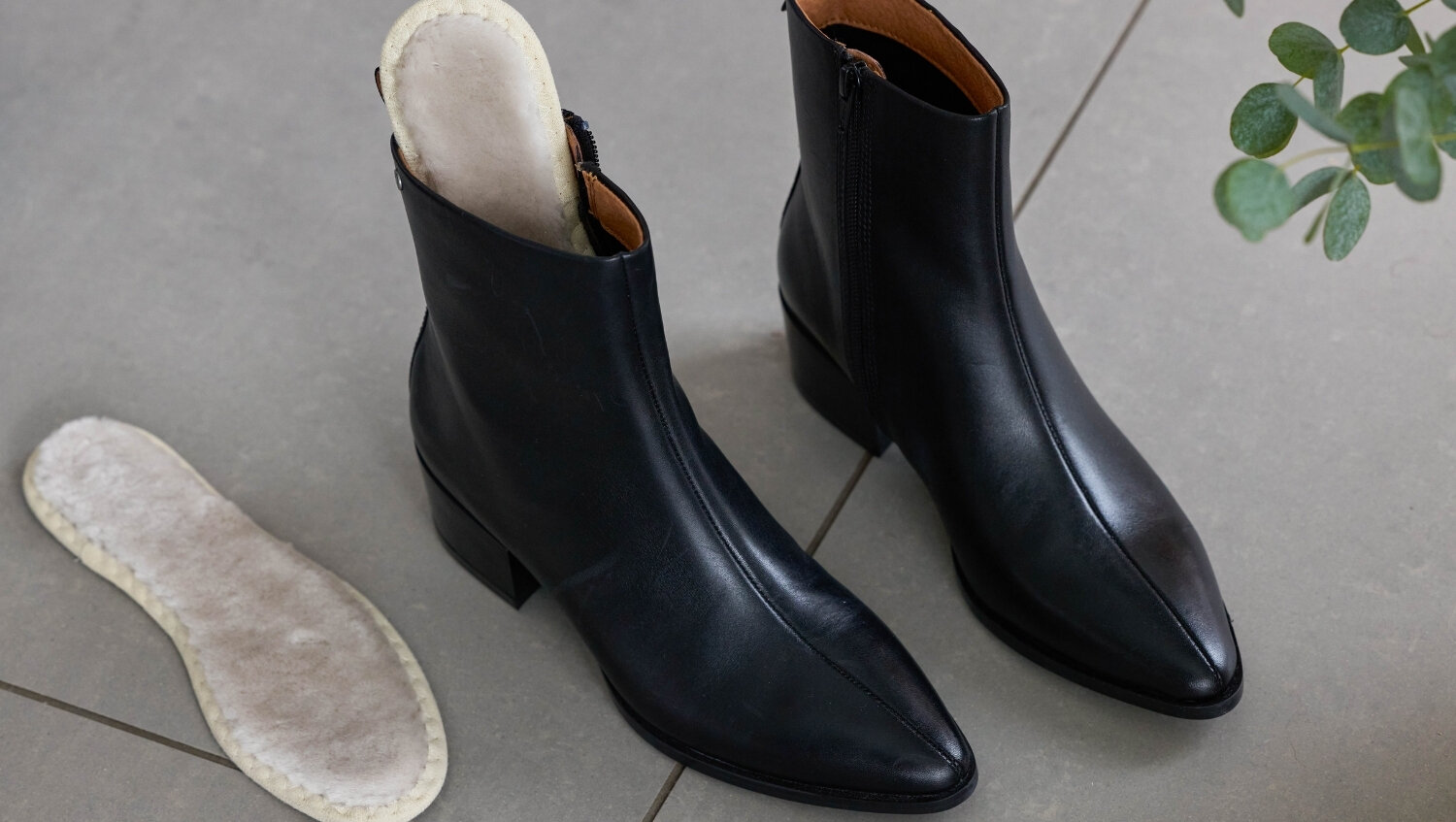 Varma, fluffiga sulor ullsulor vid ett par svarta boots